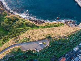 Top-down drone view of cliff road and coastal vegetation in Ribeira Brava, Madeira
