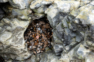 Colourful pebbles inside rock hole