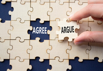 Agree or Argue symbol. Concept word Agree or Argue on wooden puzzle. Businessman hand. Beautiful deep blue background. Business and Agree or Argue concept. Copy space