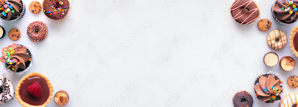 Poster dessert double border with a variety of sweets. top view on a white stone banner background with cop