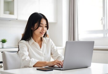 Focused Work: A woman engrossed in her work using a laptop in a brightly lit interior, her expression conveying both concentration and contentment.