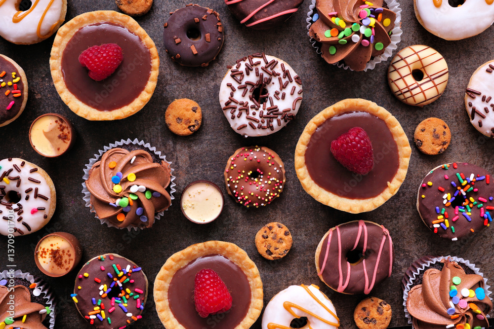 Poster Dessert background with a selection of sweets. Top view on a dark stone background.