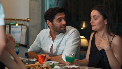 Couple or group friends drinking colorful mixed cocktail while waitress serving main course on dinner table with celebrating special party at nightclub restaurant in food and drinks tasty. Vinosity.
