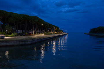 Night streetlights reflecting on calm water