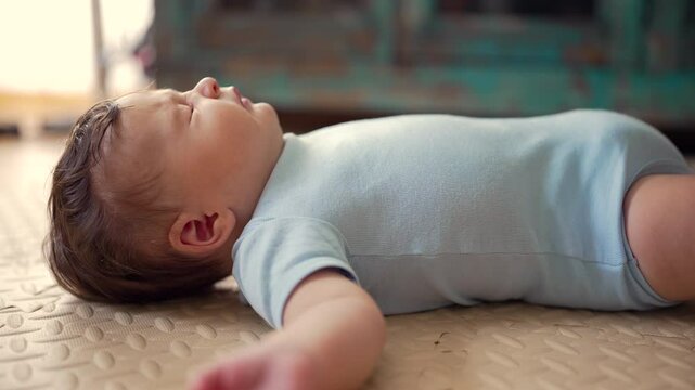 Baby lying on soft mat, sneezing, natural reflex, tiny movement, early development, spontaneous reaction, real-life moment, comfort and safety in home setting