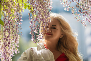 Wisteria Woman Spring: Woman poses with wisteria in spring sunshine to enjoy natural beauty...