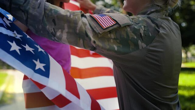 US military mom wraps her little daughter in national flag, showing patriotism