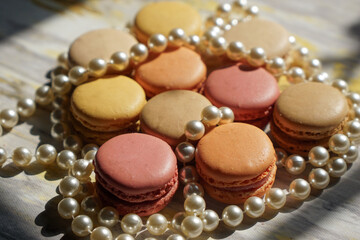 Macaroons of different colors with different flavors and pearl beads. Sweet treats for guests to the wedding or party.