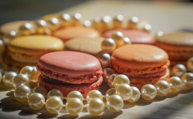 Macaroons of different colors with different flavors and pearl beads. Sweet treats for guests to the wedding or party.