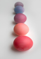 Easter eggs in purple and pink shades are lying on a white background with a shadow photo