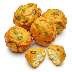 A group of golden fried vegetable pakoras with one cut open on a white background studio shot