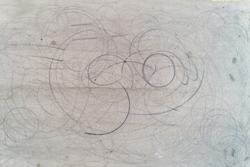 A grey surface with many black lines drawn on it