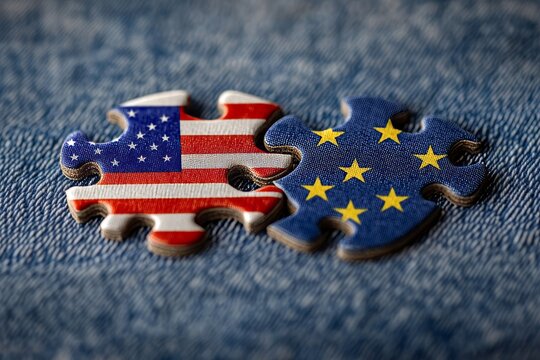 Puzzle pieces of european and american flags on denim, symbolizing collaboration and unity