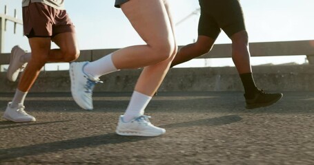 Fitness, legs and group with running on bridge for marathon training, cardio exercise and performance pace. People, runner club and sneakers in road for wellness competition, morning jog and workout