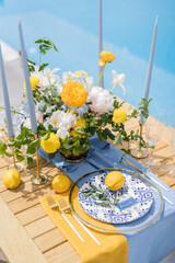 Name card lies on a plate next to a lemon and an olive branch on a holiday table