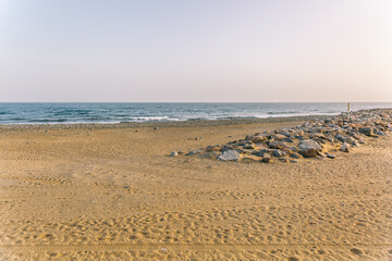 A beach with a rocky shoreline and a calm ocean