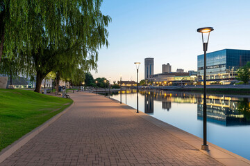 Rochester riverfront path with Mayo Civic Center reflected in Zumbro River at dusk