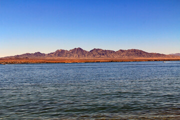 View of California mountains across Lake Havasu in Lake Havasu State Park in Lake Havasu City, Arizona, USA with blue sky copy space.