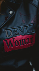 Leather Jacket with "Devil Woman" Text, Dark Background, Close-up Shot