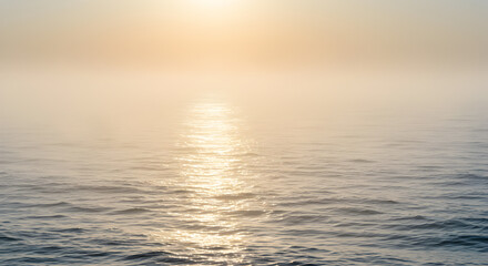 Fototapeta premium Ephemeral beauty: sunlit ocean veiled in ethereal morning mist horizon