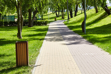 Walkway surrounded by trees and lawns in Kyiv, Europe. Recreation place in the city park