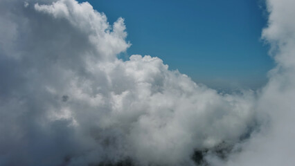 Obraz premium Flying through white fluffy clouds