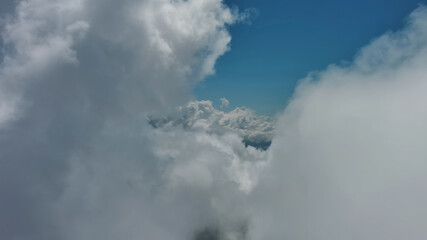 Obraz premium Flying through white fluffy clouds