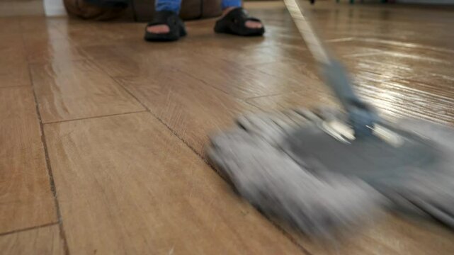 Professional janitor methodically mopping tiled floor, rotating cleaning tool and ensuring spotless, hygienic surface with precise workplace maintenance