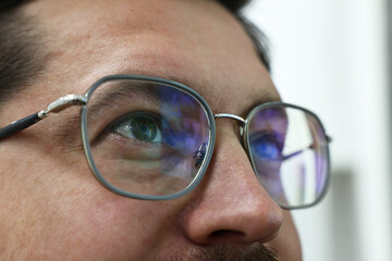 Man wearing stylish glasses on blurred background, closeup