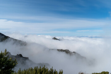 A view of mountains rising into the sky, partially hidden by clouds.
