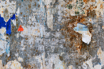 Muro con ruggine e manifesti strappati