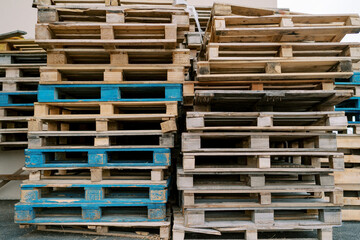 Wooden pallets stacked near the outer wall of a warehouse