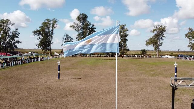 Argentine flag waving in the wind at a gaucho horse riding event
