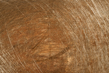 Weathered steel surface displaying deep scratches, revealing aged texture with rich, warm brown patina highlighting surface imperfections