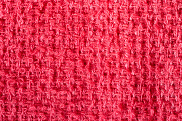 Textured red towel fabric showing intricate woven loops, creating detailed surface pattern ideal for textile design backgrounds and visual compositions