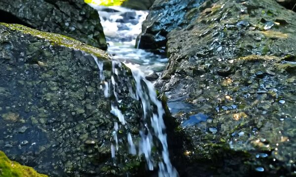 Spring of water flowing from rock and stones