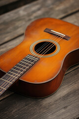 Fototapeta premium Craftsmanship of a wooden acoustic guitar resting on a rustic wooden surface