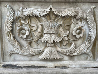 Ornate symmetrical stone relief with crown centerpiece and swirling flower details Stone relief...