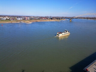 Fototapeta premium Nijmegen Serenity: River Reflections Under a Vast Blue Sky.