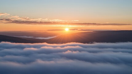 Fototapeta premium A breathtaking sunrise over an endless sea of clouds from a mountain peak.