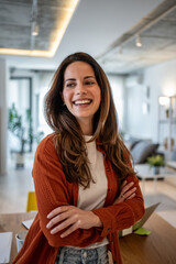 Cheerful businesswoman smiling with crossed arms in modern office