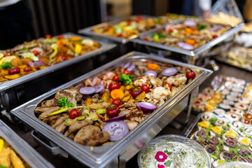 Delicious buffet spread featuring grilled meats, colorful vegetables, and vibrant garnishes at a festive event