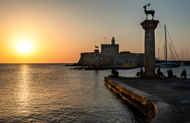 Sunrise over the harbor of Rhodes old town. Entrance to Port of Rhodes at first sunlight. Rhodes...