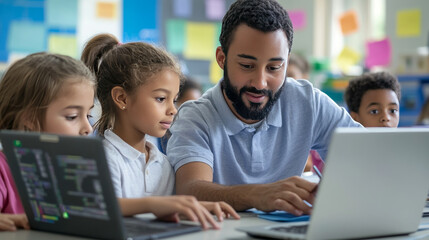 Fototapeta premium Elementary School Science Class: Over the Shoulder Little Boy and Girl Use Laptop with Screen Showing Programming Software. Physics Teacher Explains Lesson to a Diverse Class full of Smart Kids