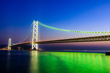 Fototapeta premium 春の舞子公園から見たライトアップされた明石海峡大橋 兵庫県神戸市 The illuminated Akashi Kaikyo Bridge seen from Maiko Park in spring. Hyogo Pref, Kobe City.