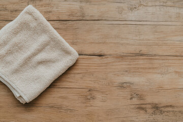 A white towel is laying on a wooden table