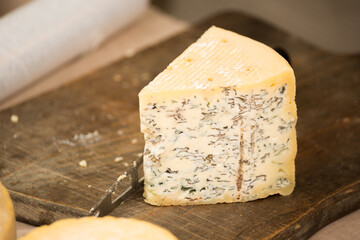 A piece of blue cheese on a wooden board