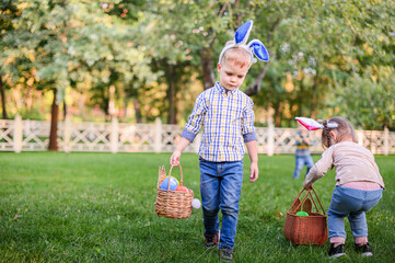 Children Hunting Easter Eggs in the Garden with Bunny Ears