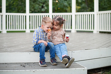 Happy Children Eating Ice Cream Outdoors on a Wooden Terrace
