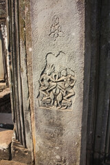 Engraved stone detail with circular carving and surrounding textured surface Chiseled pattern emerges from the weathered stone, revealing ornate shapes and symbolic motifs